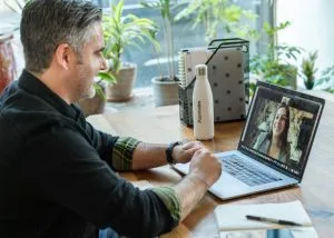 man in black sweater using macbook pro