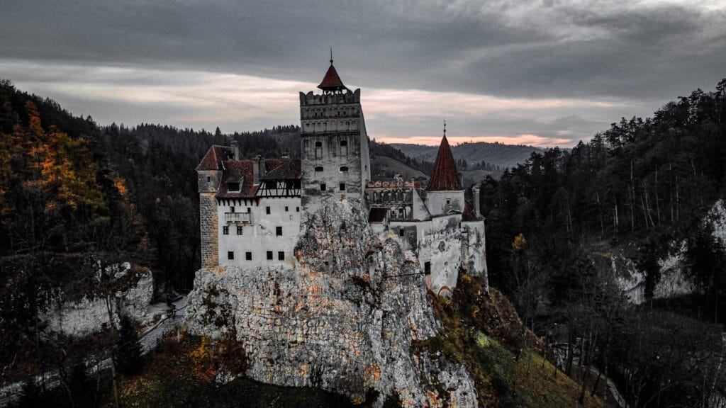 a castle on top of a mountain with a cloudy sky