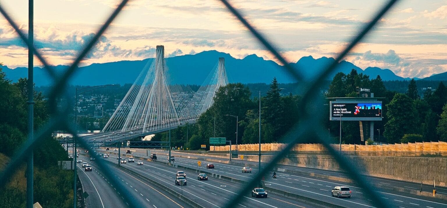 a view of a highway through a fence