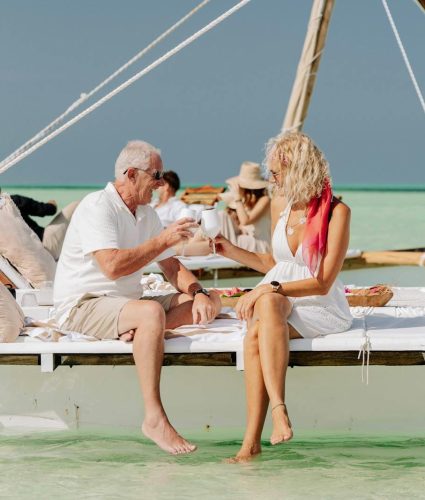 Elderly couple enjoying a serene boat ride on the turquoise waters of Zanzibar.