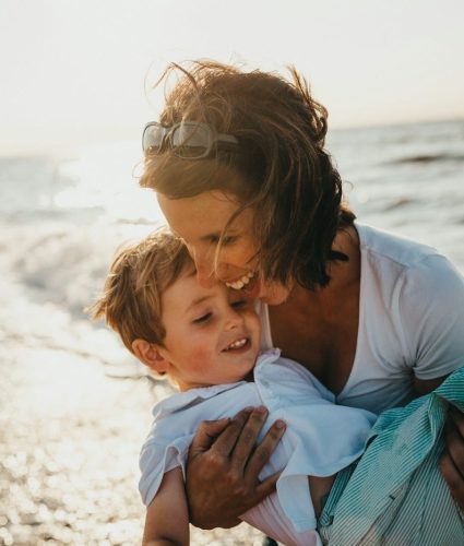 photo of mother and child beside body of water